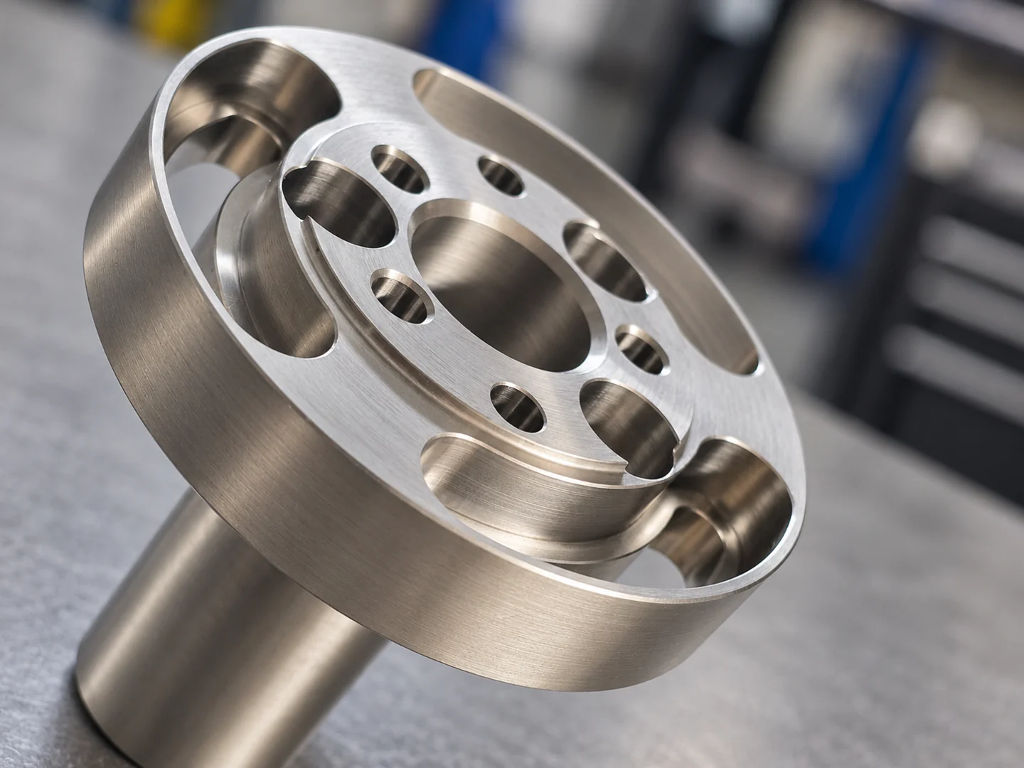 Rundes Metallbauteil mit zentraler Bohrung und umlaufenden Durchbrüchen
